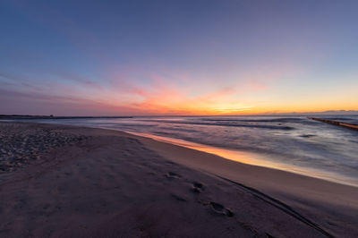 Scenic view of beach against sky during sunset