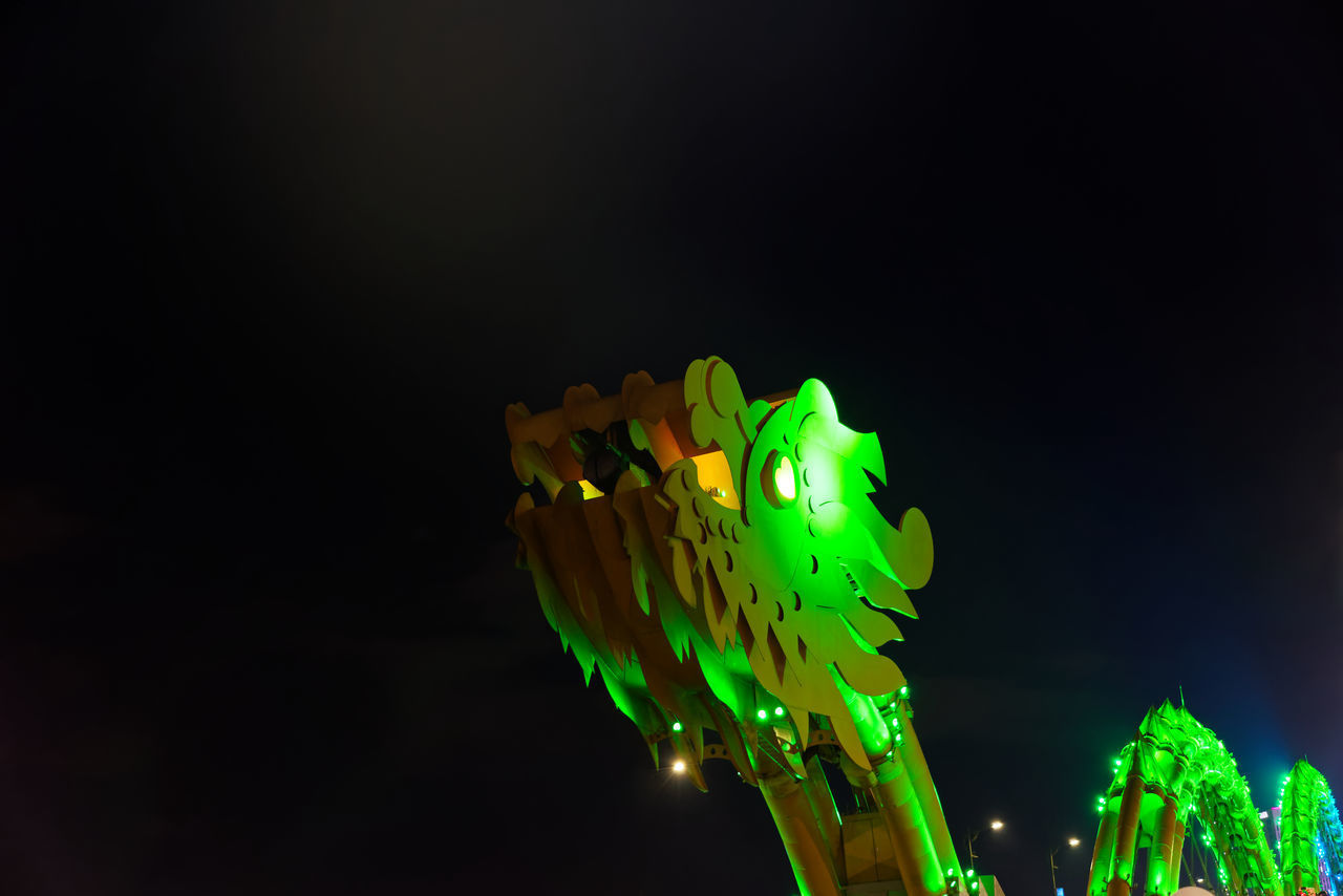 LOW ANGLE VIEW OF ILLUMINATED LIGHTING EQUIPMENT AGAINST SKY AT NIGHT