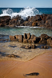 Scenic view of rocks on beach against sky