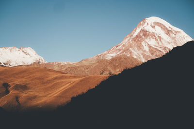 Scenic view of snowcapped mountains against clear sky