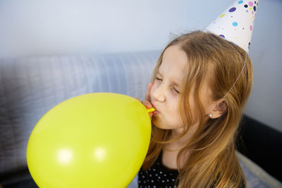 Children have fun playing, blowing up colorful balloons, at a birthday party