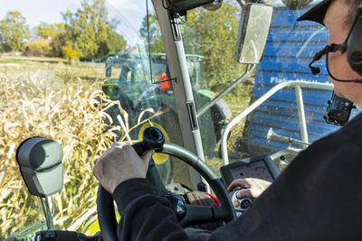 Man in forage harvester on maize field