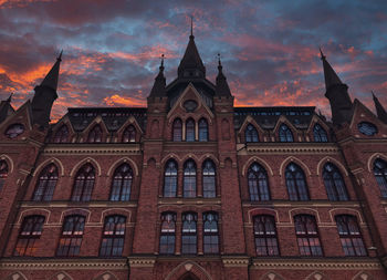 Low angle view of building against cloudy sky