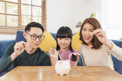 Group of people looking down while sitting on table