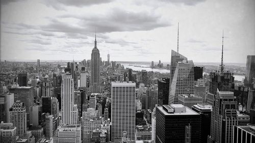 Modern buildings in city against cloudy sky