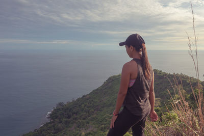 Young woman looking at sea against sky