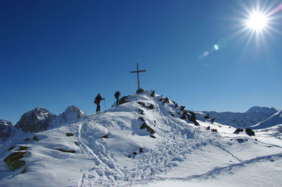 Low angle view of snow covered mountain against blue sky