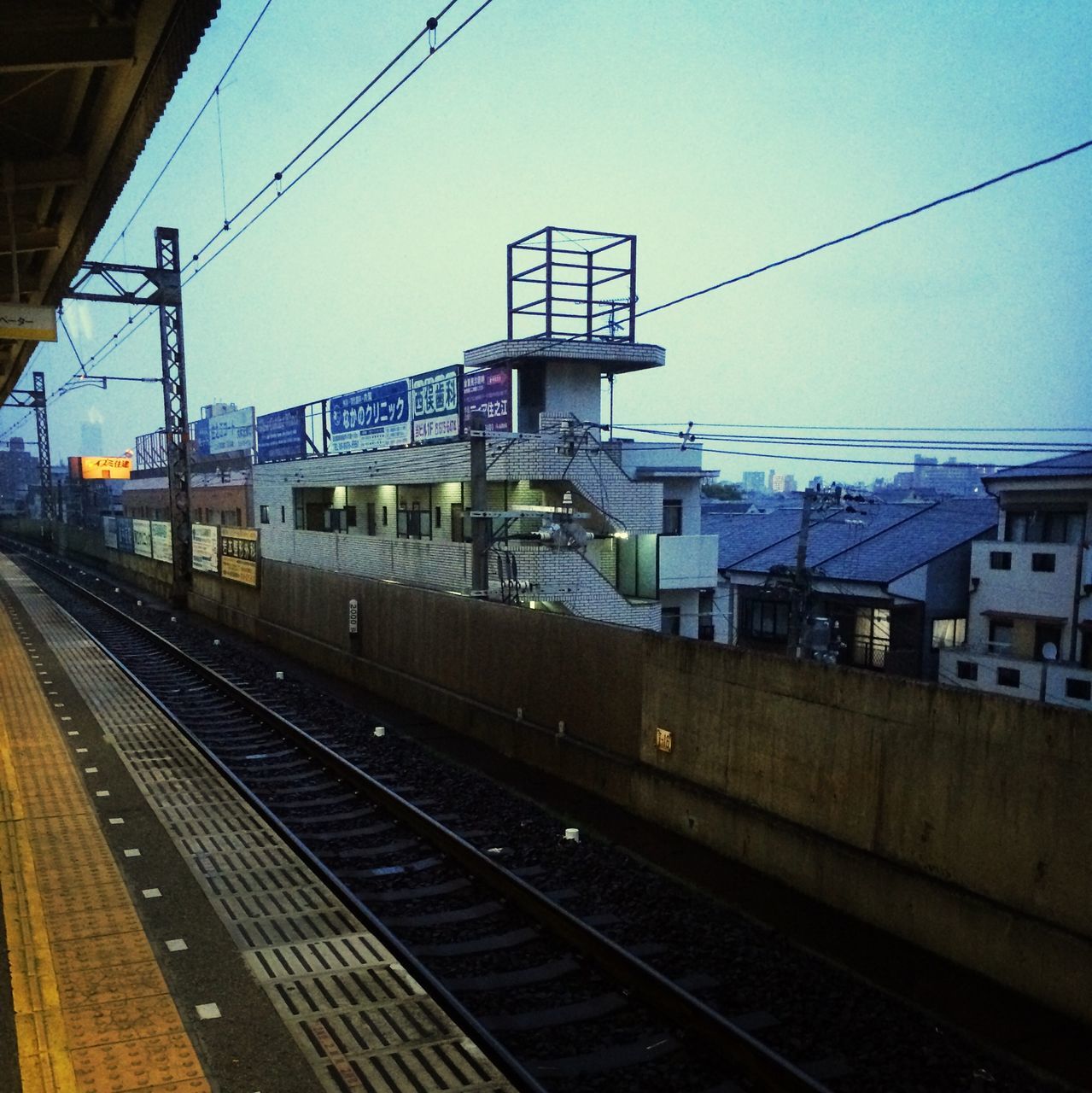 railroad track, rail transportation, railroad station platform, railroad station, public transportation, transportation, power line, built structure, train - vehicle, architecture, building exterior, cable, electricity pylon, railway track, electricity, power supply, passenger train, sky, train, connection