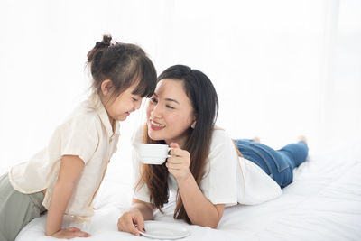 Happy friends lying on bed
