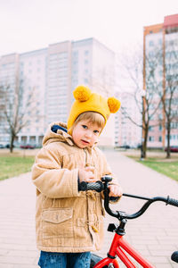 A small child learns to ride a bike for the first time in the city in spring