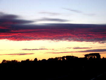 Silhouette of landscape against cloudy sky during sunset