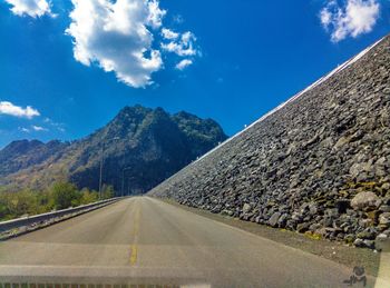 Road by mountain against sky