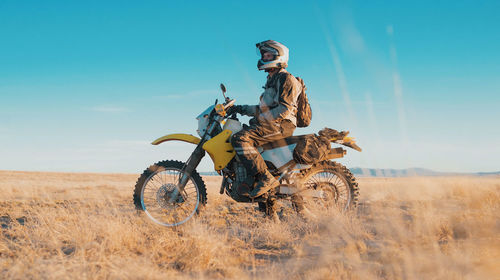 Man on motorcycle in desert during sunset