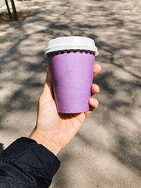 Hand holding a takeout coffee cup