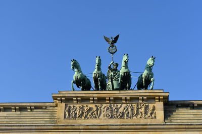 Low angle view of statue against blue sky