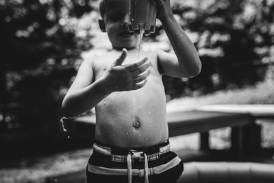 Shirtless boy holding toy