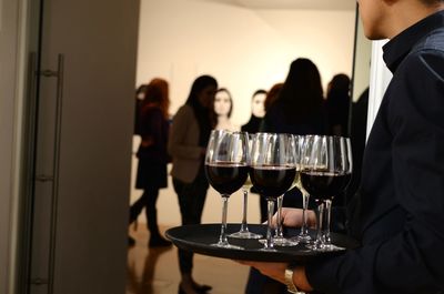 Waiter carrying tray of wineglasses at party