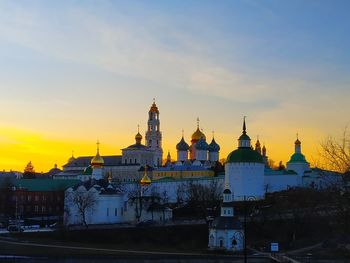 Buildings in city against sky during sunset