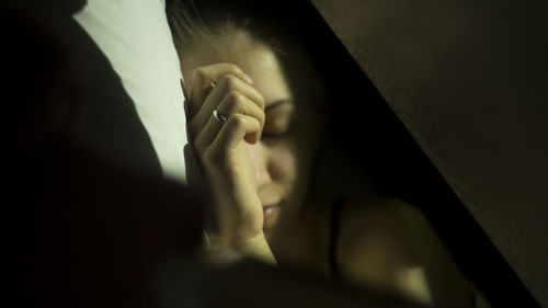 Close-up of woman sleeping on bed at home