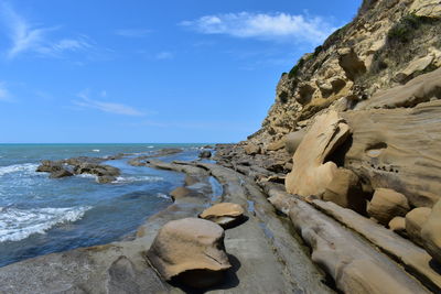 View of sedimentary rock formations against sky