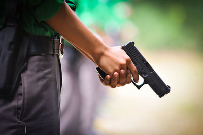 Midsection of man holding gun