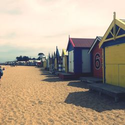 Houses on beach by buildings against sky