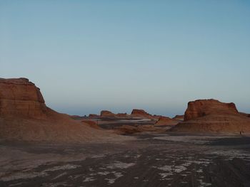 Rock formations on landscape against sky