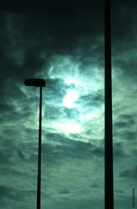 Low angle view of street light against cloudy sky