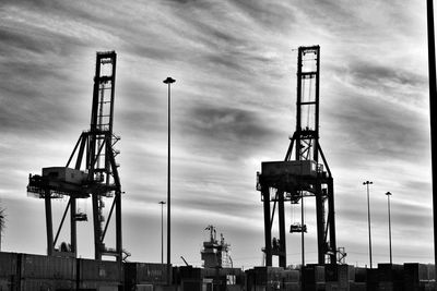 Low angle view of cranes against sky