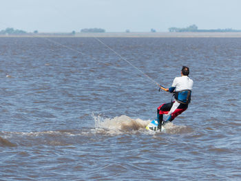 Rear view of man surfing in sea