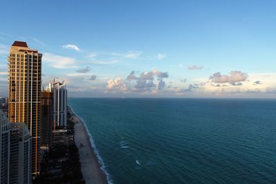 Sea by buildings against sky