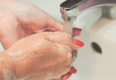 Close-up of hand holding water in bathroom