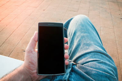 Midsection of person using mobile phone