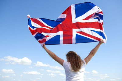 Low angle view of woman against blue sky