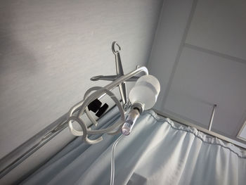 Low angle view of iv drip hanging on stand at hospital