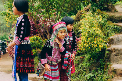 Full length of woman standing by flowering plants