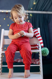 Portrait of cute boy sitting on sofa at home