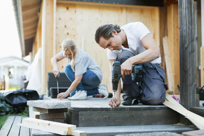 Couple working outside house during home improvement