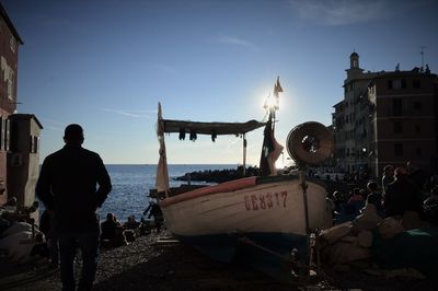 People by boat at beach in camogli