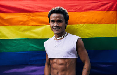 Portrait of young man standing against american flag