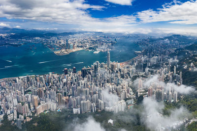 High angle view of city by sea against sky