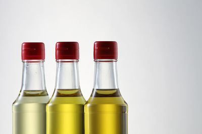 Palm oil, sesame seed oil, olive oil, grape seed oil and corn oil in glass bottle over white 