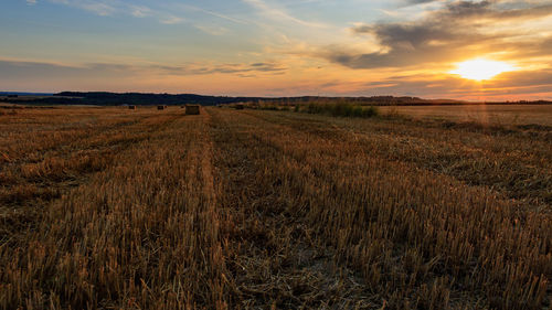 Scenic view of field with hay bales against sky during sunset in möckmühl, germany