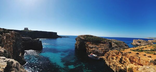 Panoramic view of sea against clear blue sky