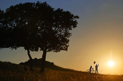 Silhouette family is playing outdoors. father and son with his kite