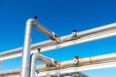 Low angle view of industry against blue sky