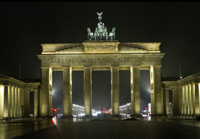 Statue in city at night