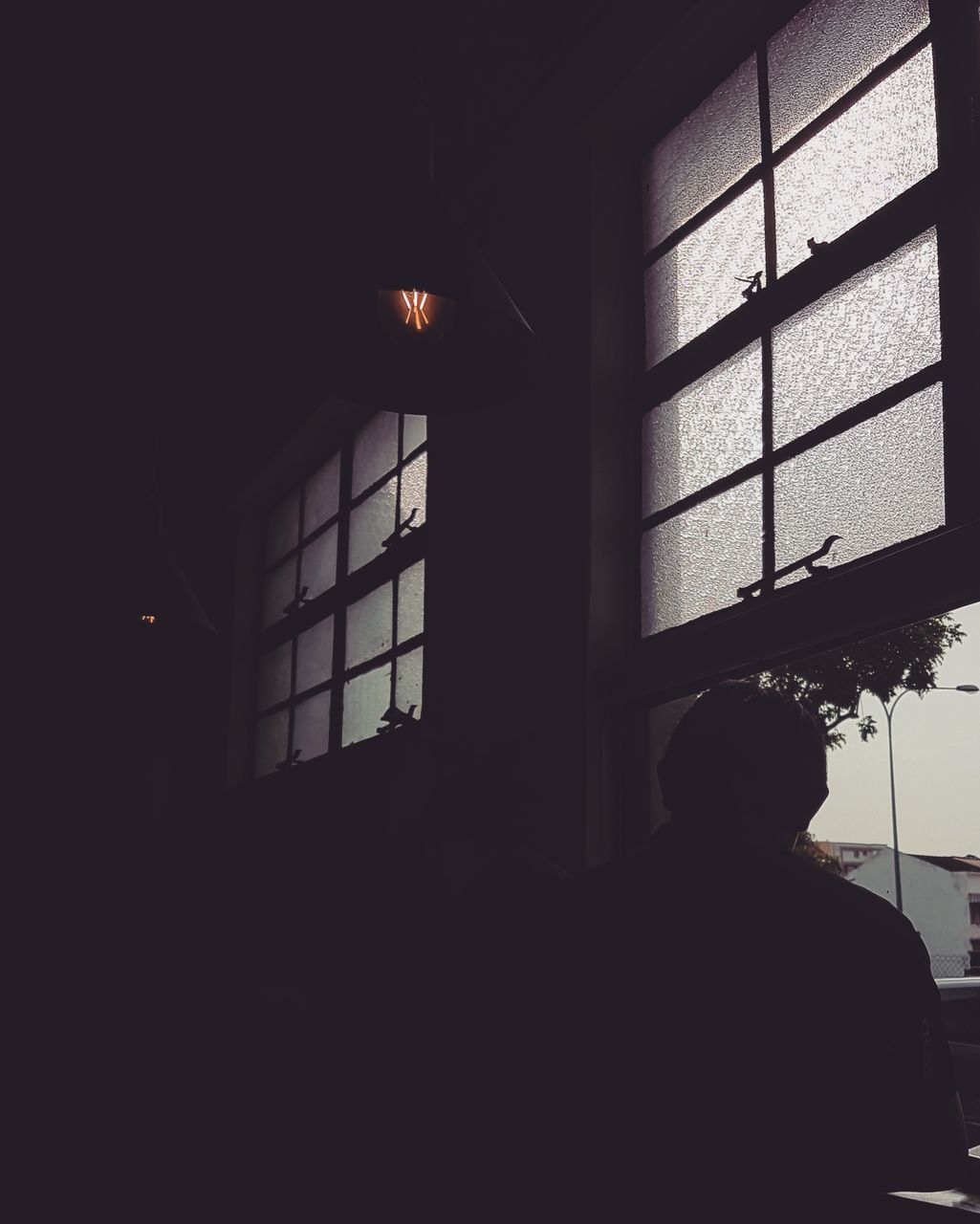 SILHOUETTE OF MAN STANDING IN WINDOW