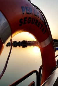 Close-up of text on swimming pool against lake during sunset