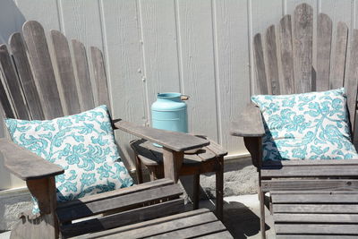 Cushions on wooden adirondack chairs against wall